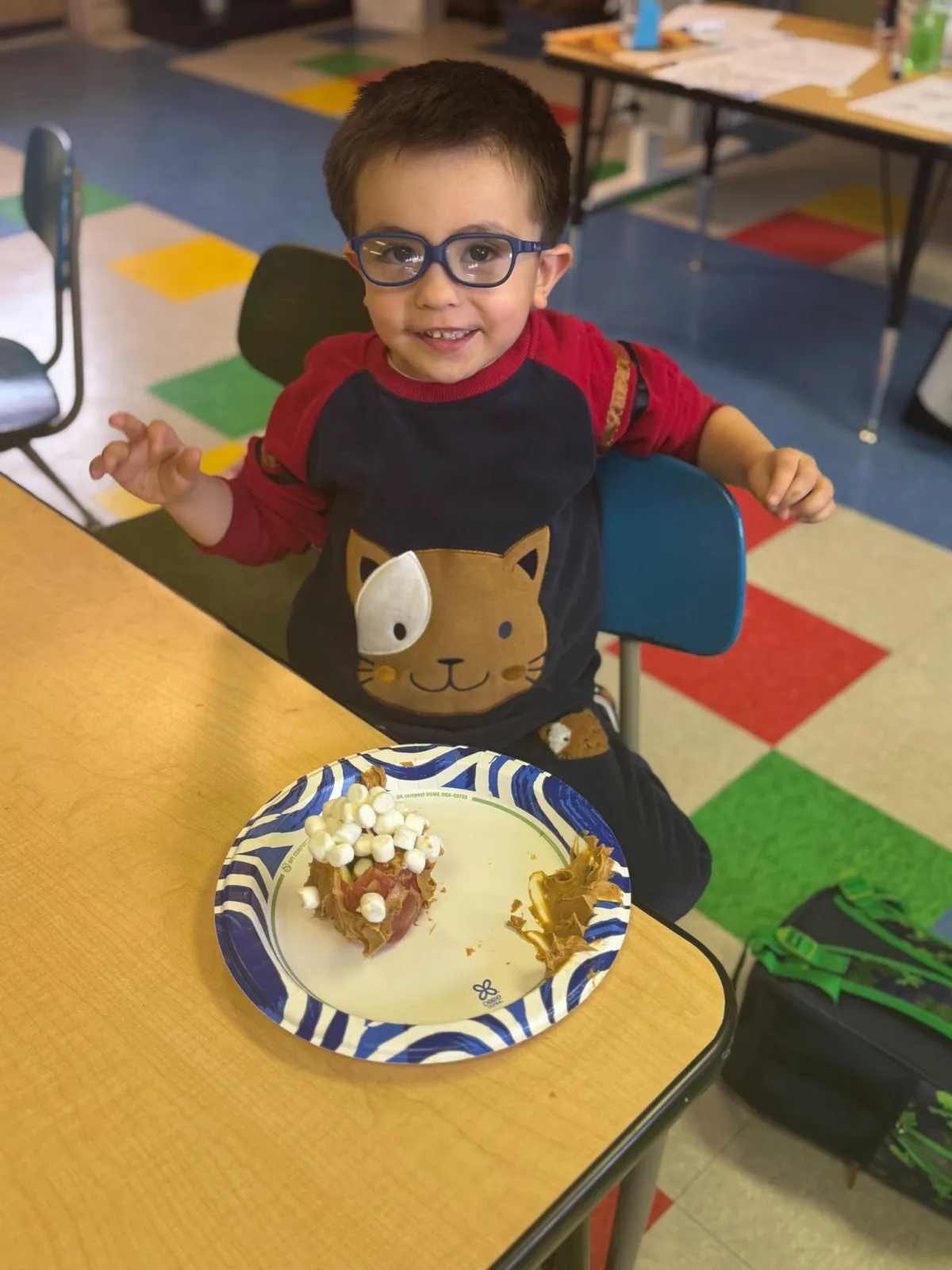 Girl stretches to the side while watching teacher on large screen TV