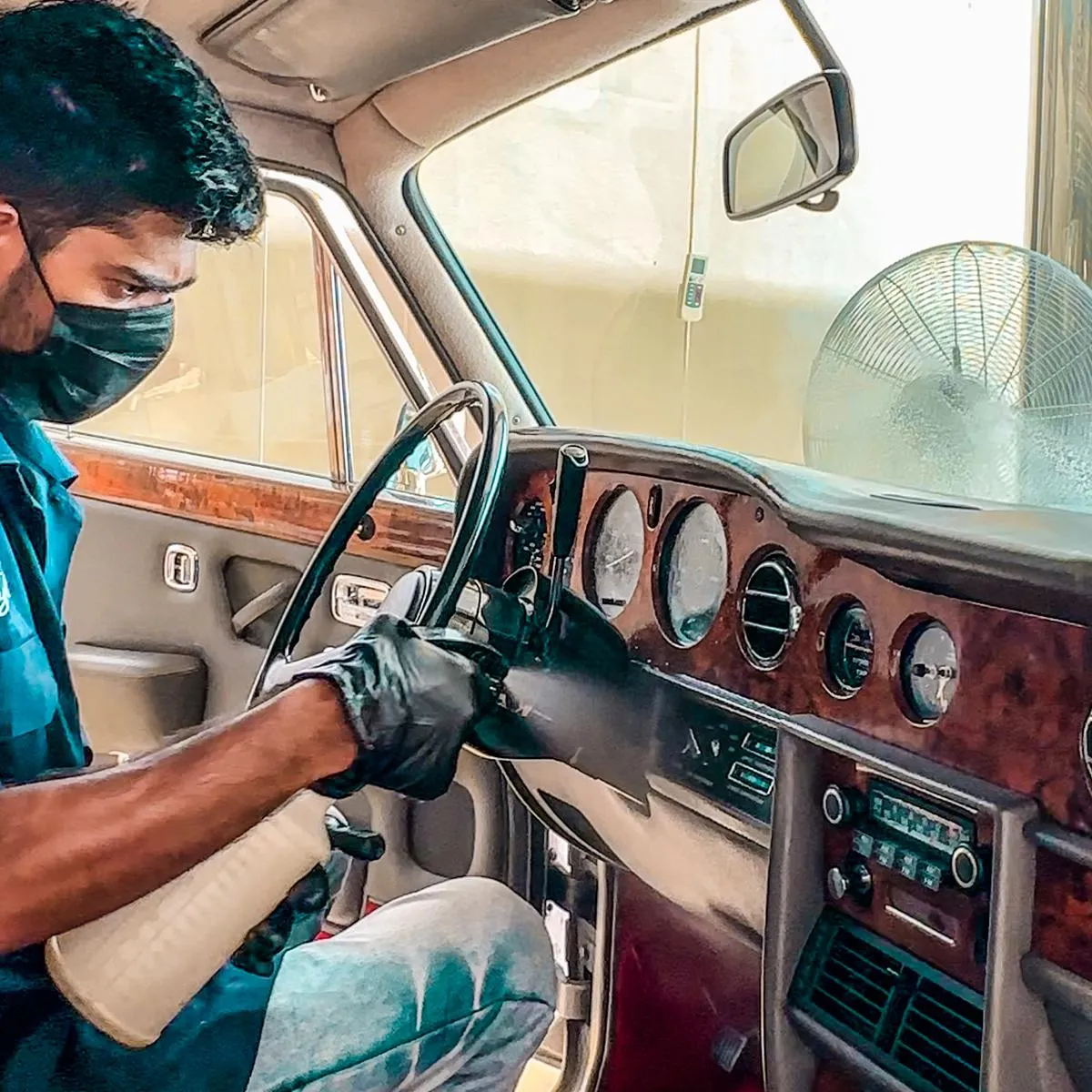 Detailer cleaning interior of a car