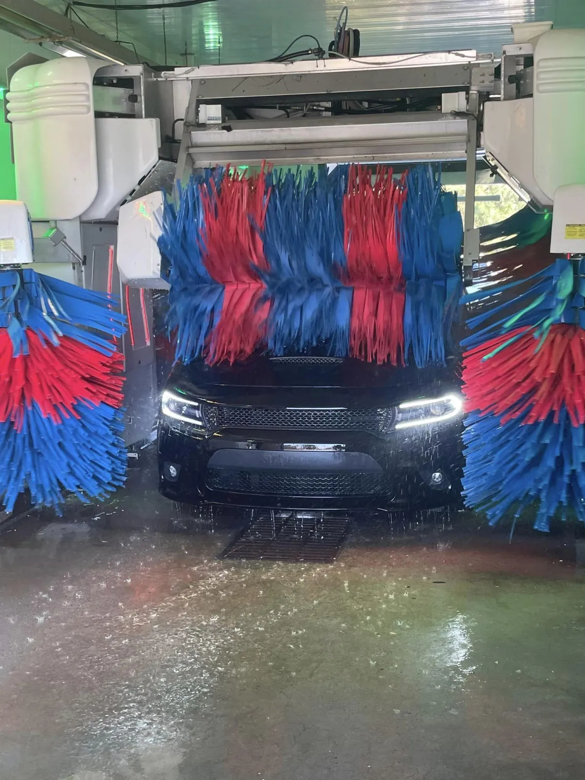 A muscle car going through a car wash at Defense Auto Wash in Fort Eustis.