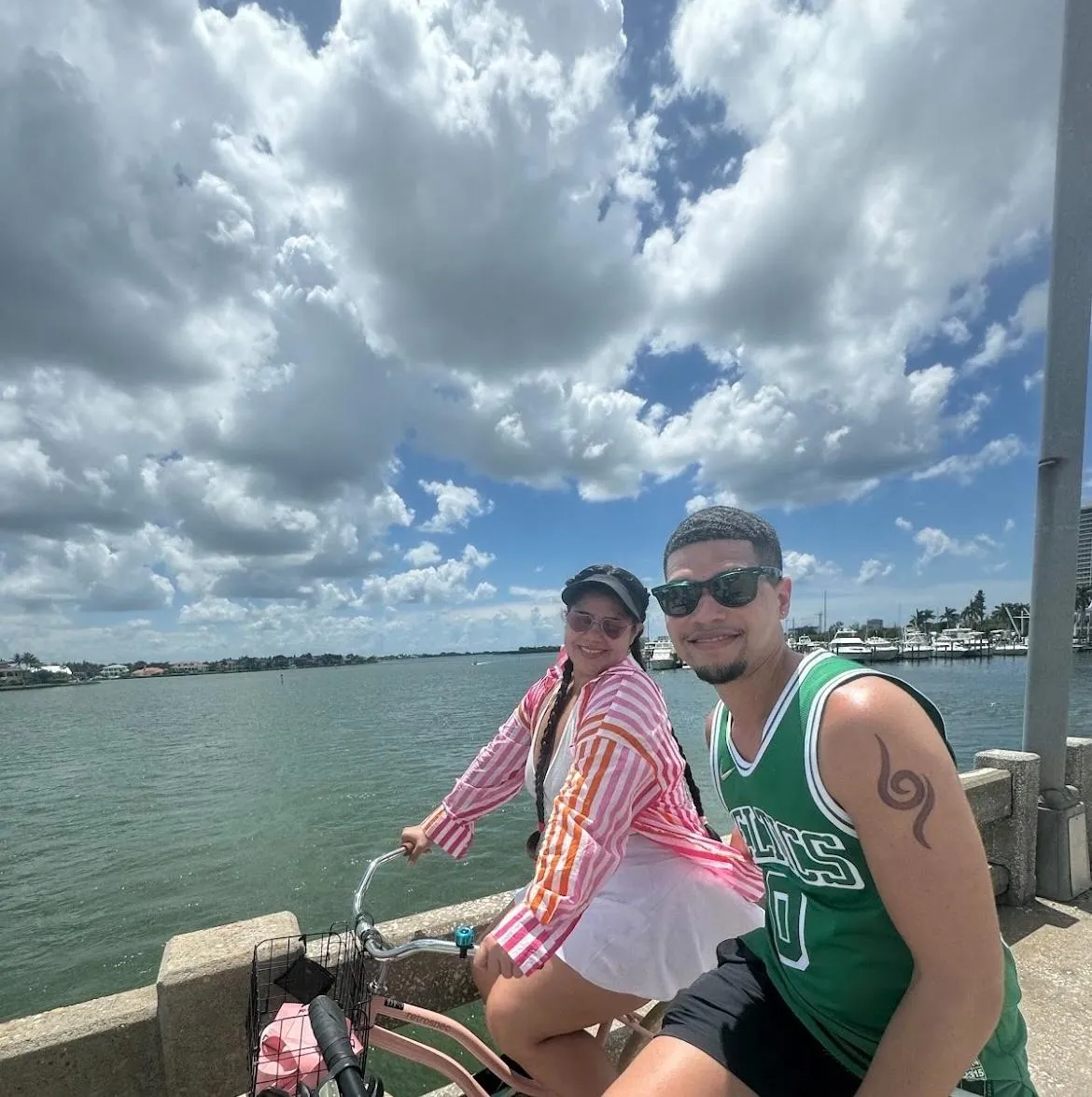 Group smiling on Bosco Rentals beach cruisers while taking a selfie on a scenic bridge near Sarasota, FL.