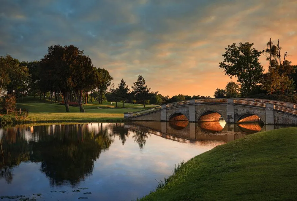 A scenic view of a golf course and mountains