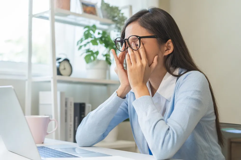 Image of a frustrated female online car vehicle registration shopper. Searching for a Montana llc car registration service on a white laptop. - Dirt Legal