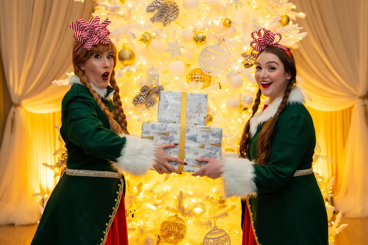 2 models pose with a Christmas gift at the Vancouver Clubs Christmas celebration event. Photo taken by events photographer, Ollie Kirwan.