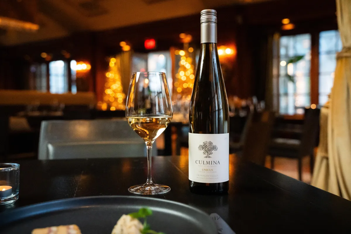 A product photography image of a bottle of wine in the restaurant of The Vancouver Club.