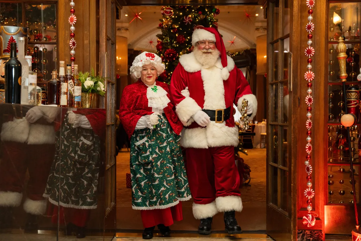 Santa Claus and Mrs Claus enter a doorway at The Vancouver Clubs Christmas celebration event. 