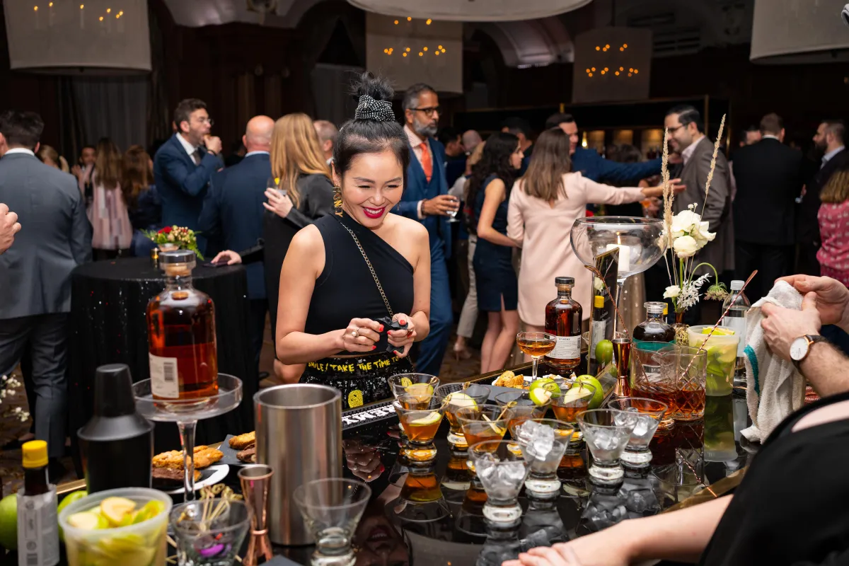 A woman tries to decide which cocktail she should try at Vancouver cocktail week event