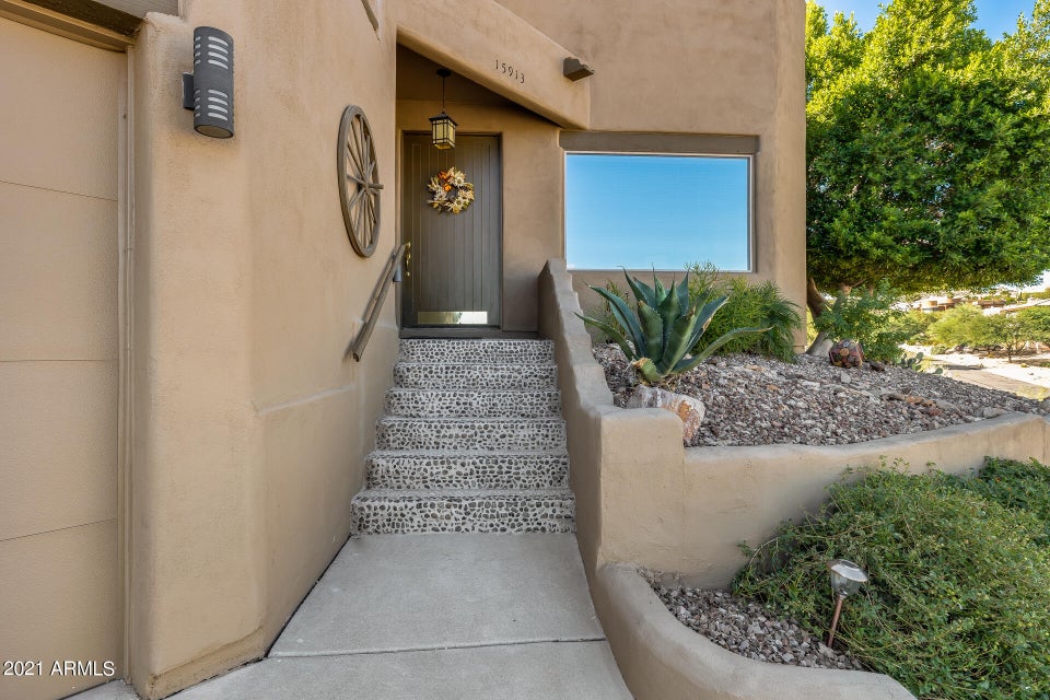 Front door with steps and greenery