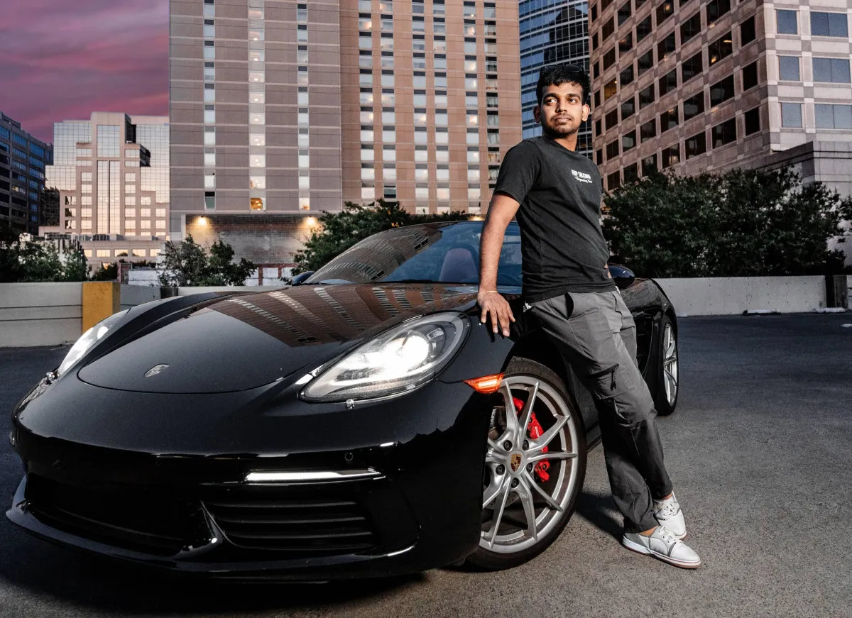 A man in a black suit loosening his tie