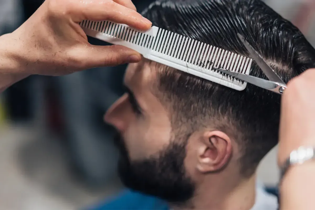 Barber giving a scissor cut with comb at Scuttlebutt Barbershop in Portsmouth, NH