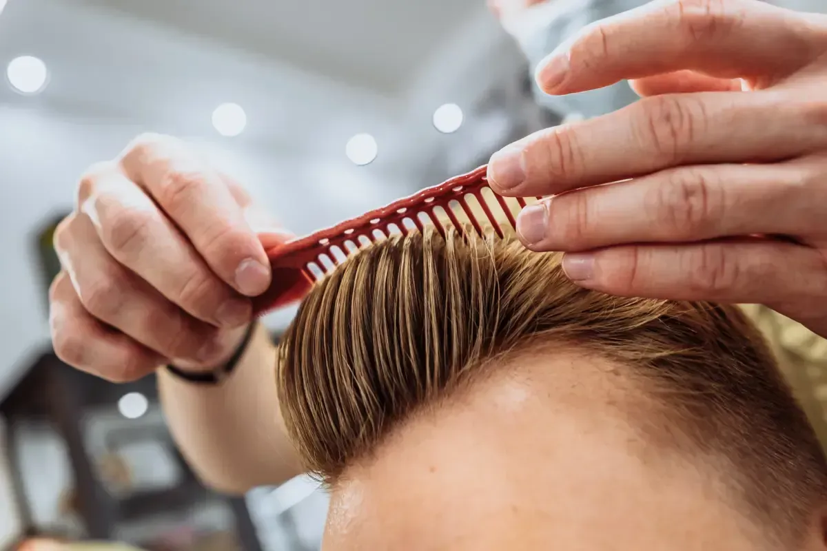 Barber styling a fresh haircut with a comb at Scuttlebutt Barbershop in Portsmouth, NH
