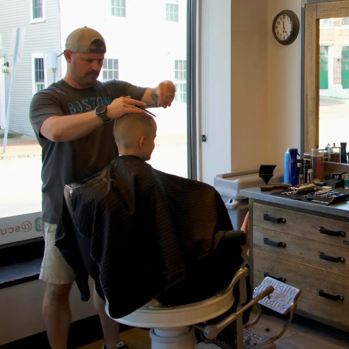 Barber giving a young boy a haircut at Scuttlebutt Barbershop in Portsmouth, NH