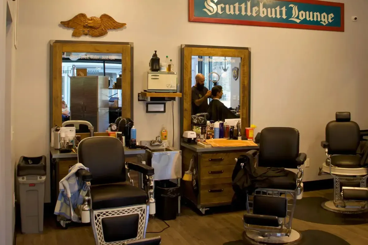 Inside Scuttlebutt Barbershop Portsmouth NH,classic barber chairs,mirrors,Scuttlebutt Lounge sign,barber cutting hair