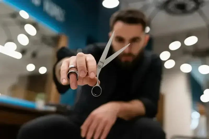 Barber holding scissors at Scuttlebutt Barbershop in Portsmouth, NH, ready for a precision haircut