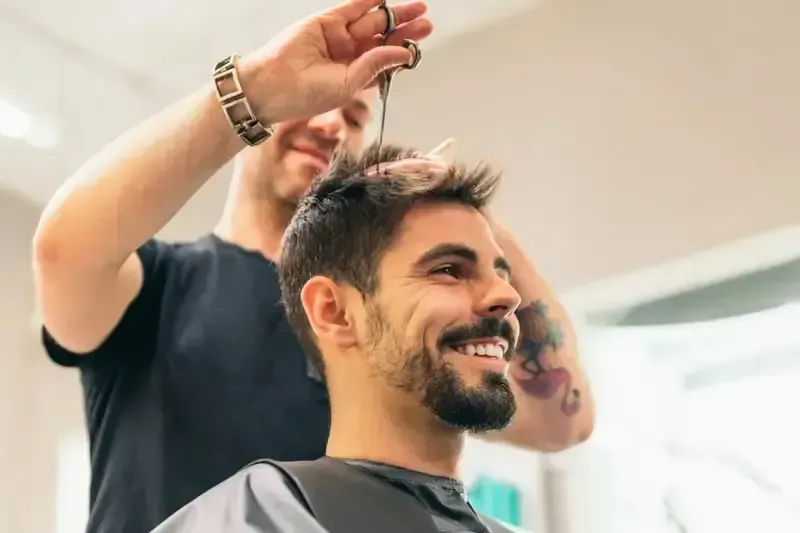 Barber giving a client a haircut at Scuttlebutt Barbershop in Portsmouth, NH