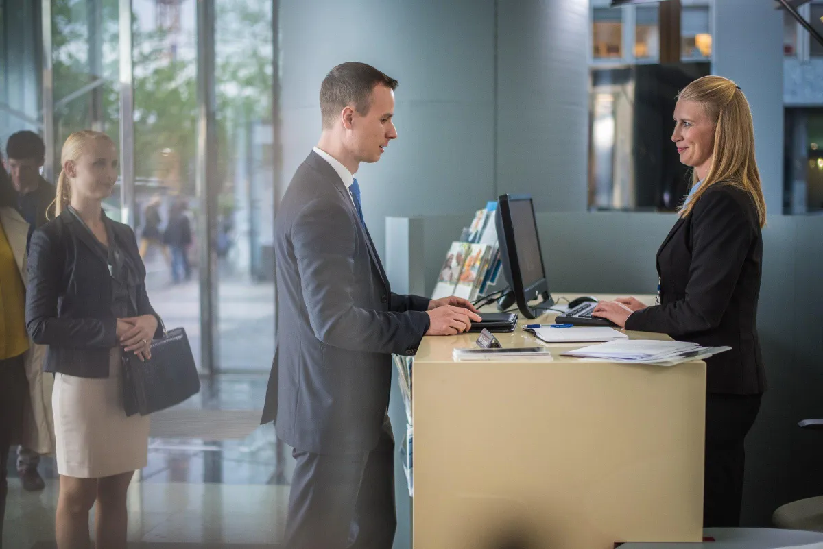 a man at a counter talking to the woman behind it