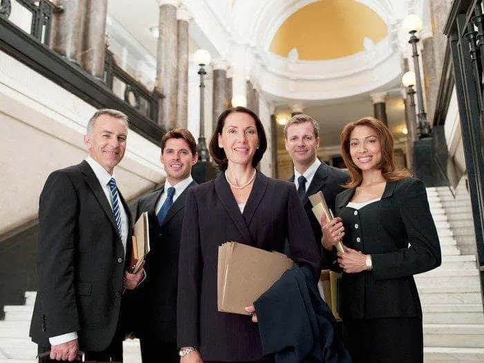 Image of a group of Lawyers standing in front of a staircase