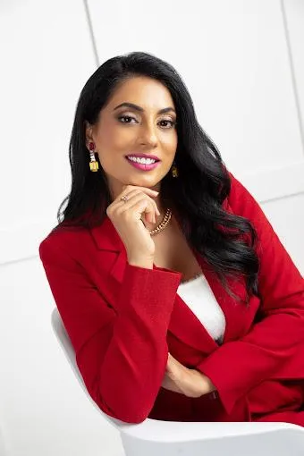 Professional photo of Aman Kaur wearing a ed sports jacket and long black wavy hair.