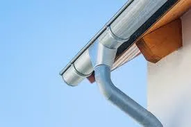 Man on a ladder working to install a steep shingle roof.
