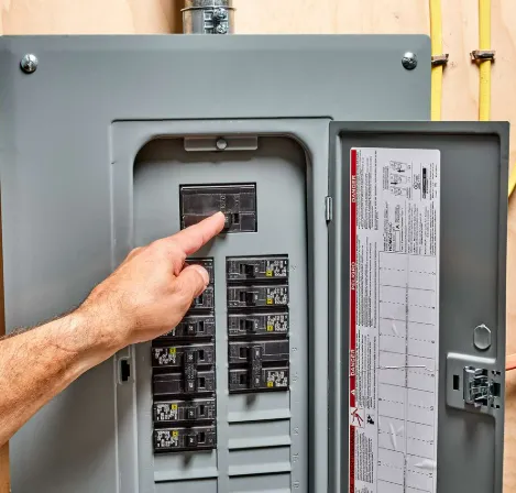 Image of a mans and and arm pointing at the main switch of a residential breaker box