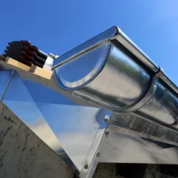 Man attaching flashing to a residential chimney rooftop