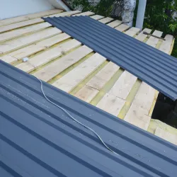 Man attaching flashing to a residential chimney rooftop