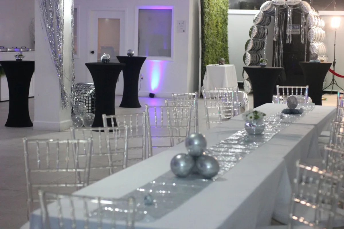 Elegant event setup with tables chiavari chairs and uplighting at Born On Purpose Hub event space in Lauderdale Lakes Florida