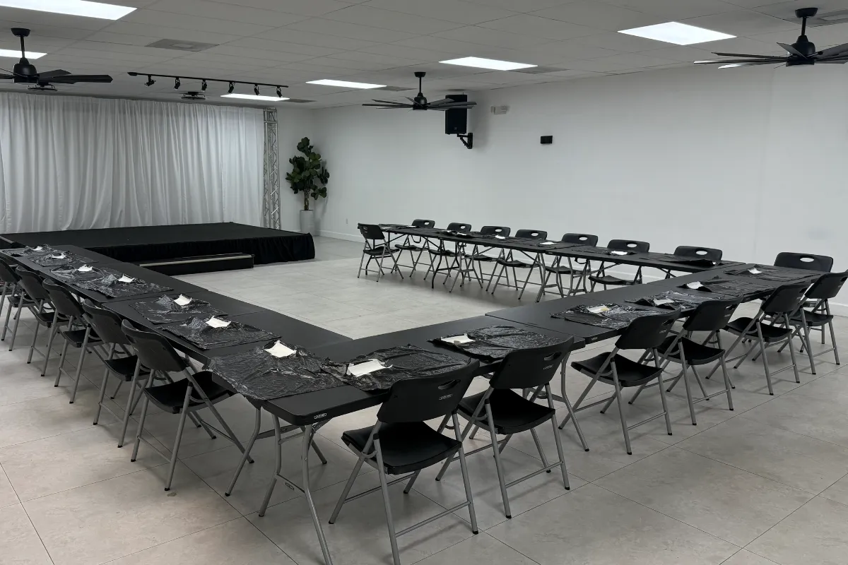 Modern corporate event space setup at Born On Purpose Hub in Lauderdale Lakes, Florida featuring U-shaped conference seating, stage platform, training workshop layout, and flexible venue rental space for meetings, seminars, leadership trainings, networking events, and professional gatherings in Broward County.