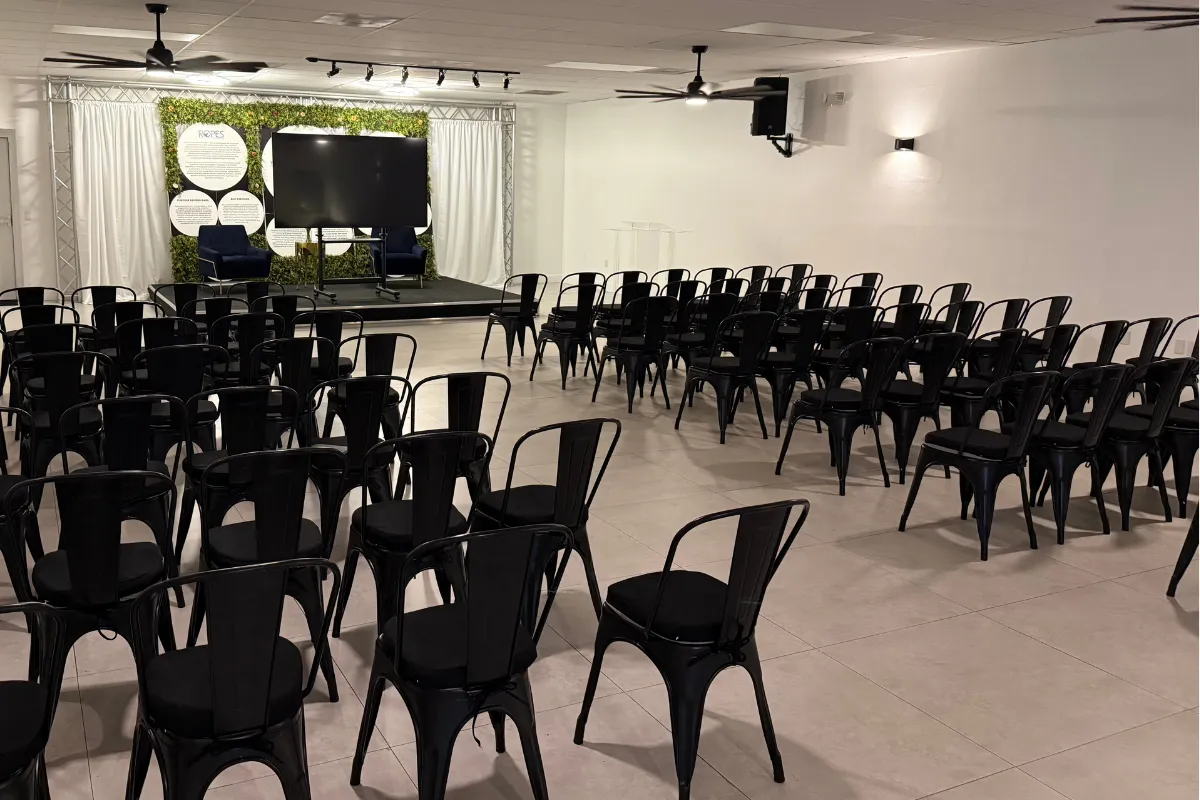 Professional meeting space in Lauderdale Lakes featuring theater-style seating, presentation stage, large display screen, sound system, and flexible event layout at Born On Purpose Hub for business meetings, workshops, trainings, and board retreats.