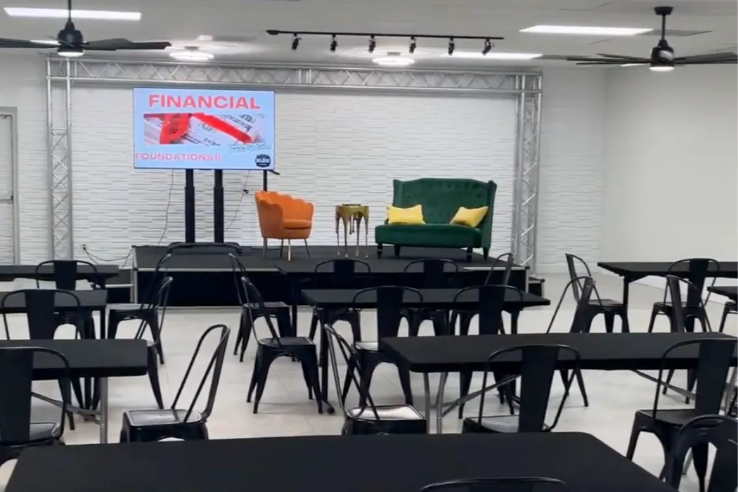 Professional event space in Lauderdale Lakes, Florida featuring a presentation stage, AV screen, flexible meeting setup, and seating for corporate trainings, workshops, seminars, nonprofit events, and business meetings.