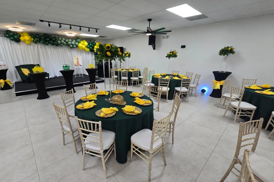 Private event venue setup at Born On Purpose Hub in Lauderdale Lakes, Florida featuring elegant table décor, chiavari chairs, stage backdrop, and flexible event space for baby showers, birthdays, repasses, corporate events, and celebrations.