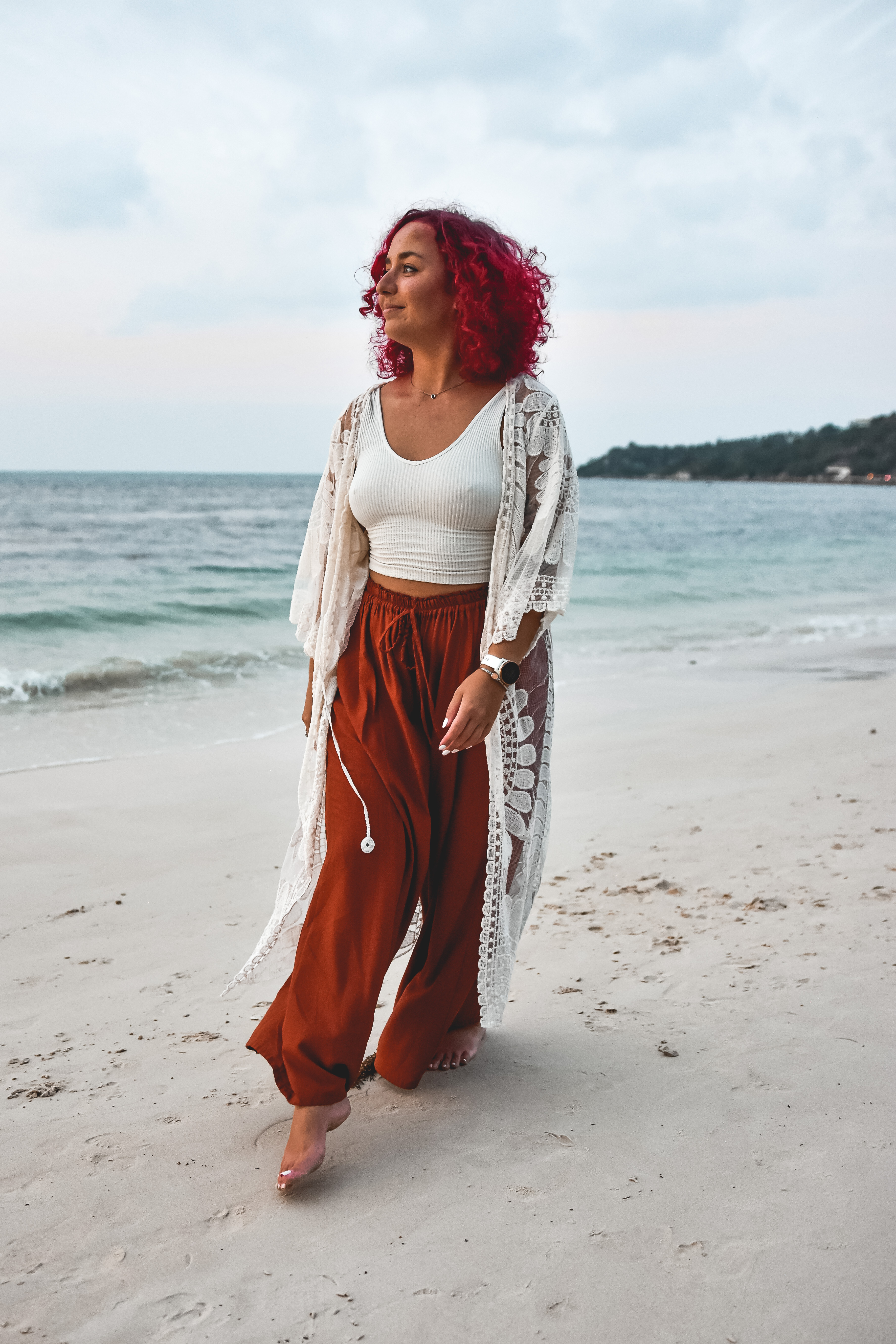 Somatic coach Gerly walking with a sense of freedom and presence along the shore, representing the ease and flow found through nervous system regulation.