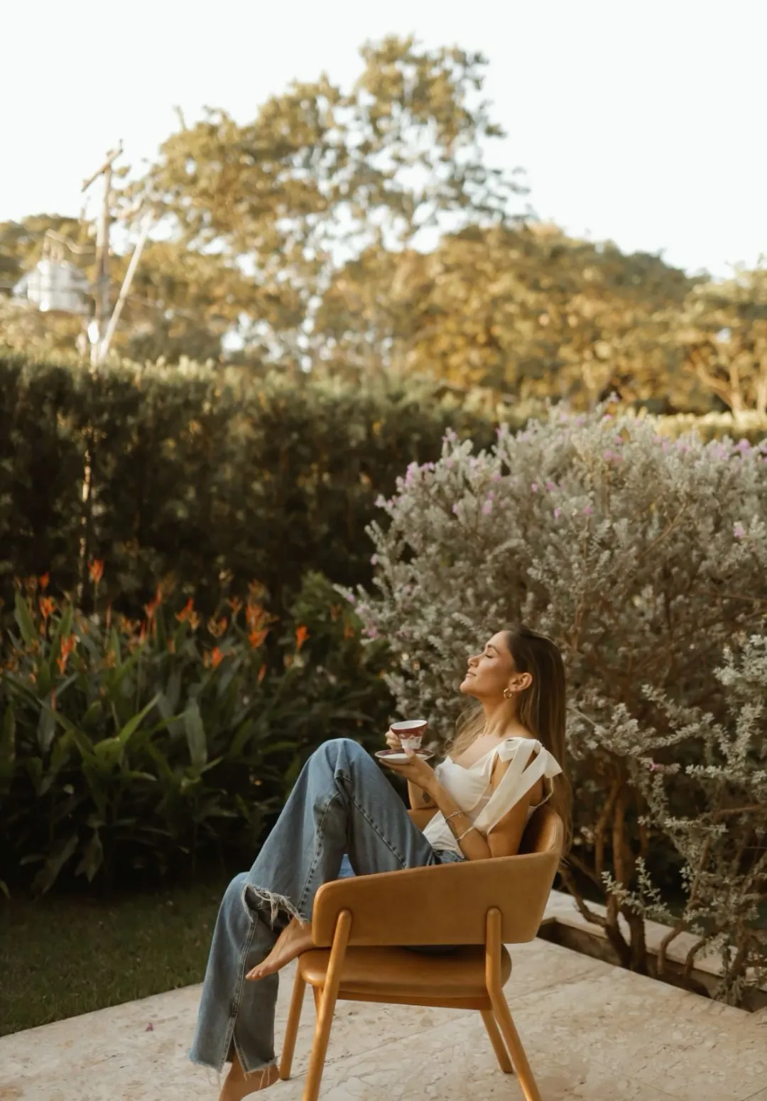 A retreat guest enjoying a quiet moment of bliss on arrival Day 1, sipping a non-alcoholic welcome drink and exhaling into the serene atmosphere of the villa—the start of a somatic journey.