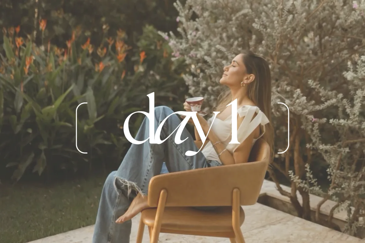 A retreat guest enjoying a quiet moment of bliss on arrival Day 1, sipping a non-alcoholic welcome drink and exhaling into the serene atmosphere of the villa—the start of a somatic journey.