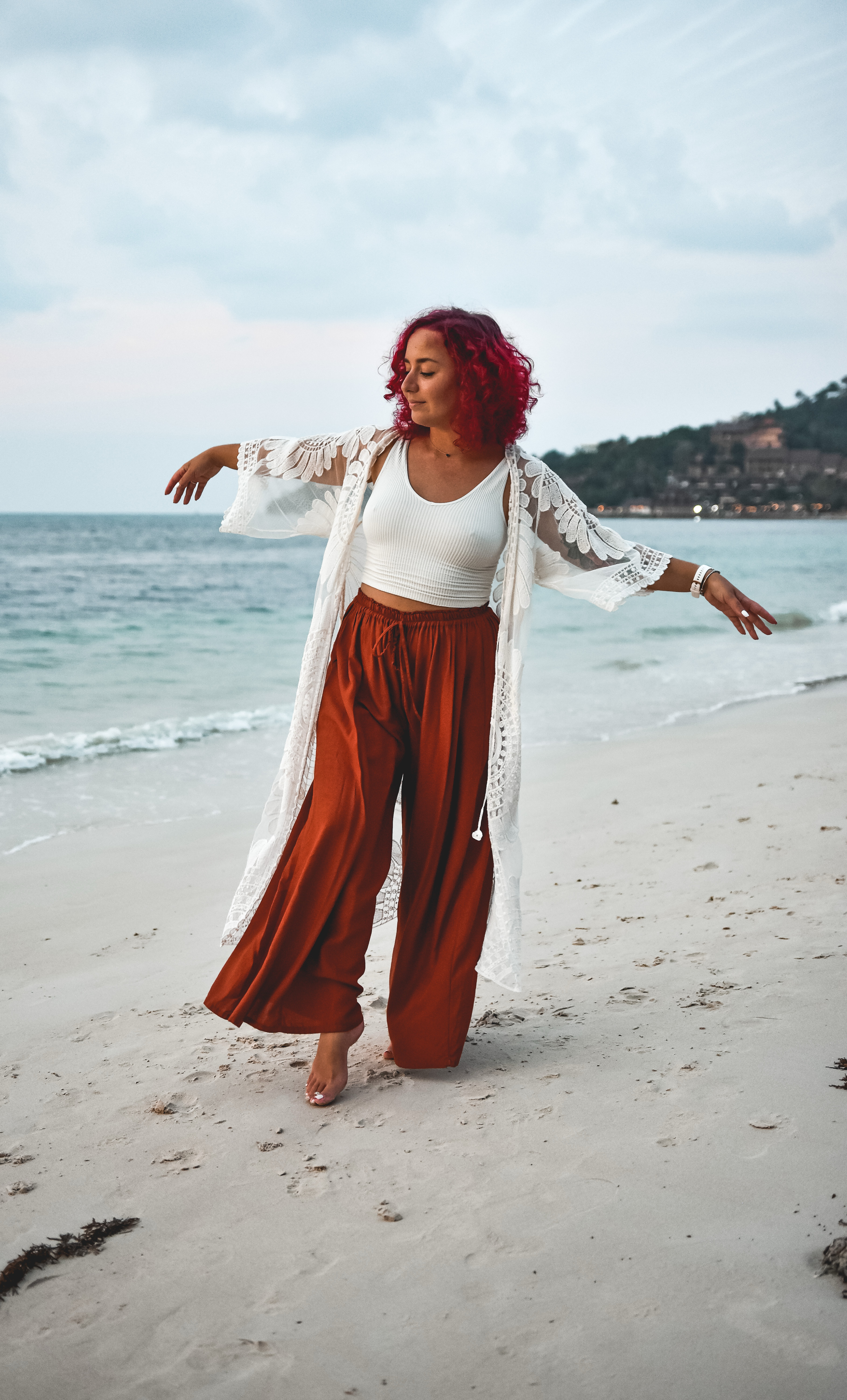 Somatic coach Gerly walking with a sense of freedom and presence along the shore, representing the ease and flow found through nervous system regulation.