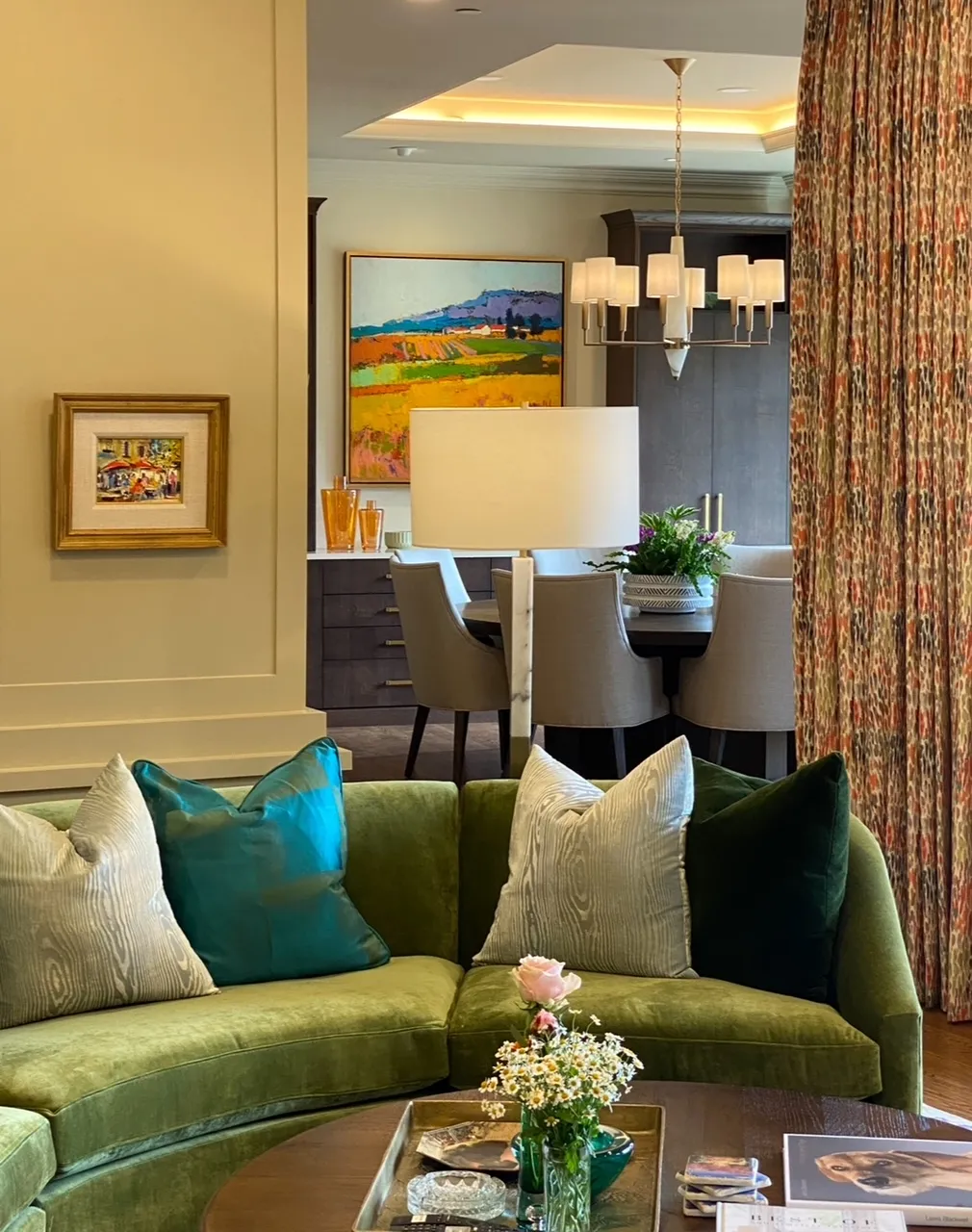 Dining area with patterned curtains and colorful landscape painting