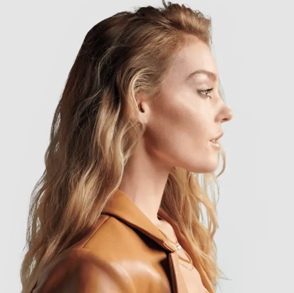 person holding clear glass bottle