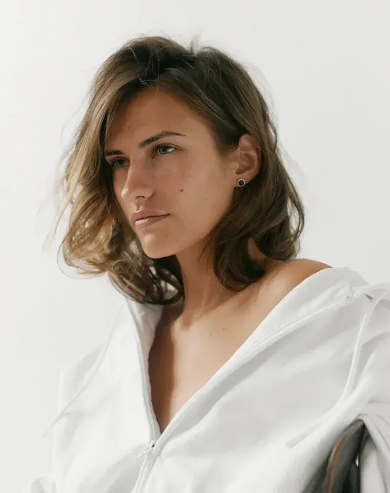 person holding clear glass bottle