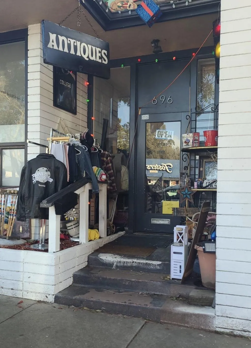 A bustling store interior with customers browsing shelves of antiques, a family examining a vintage globe, and a staff member assisting at the counter. The space is bright, organized, and full of character.