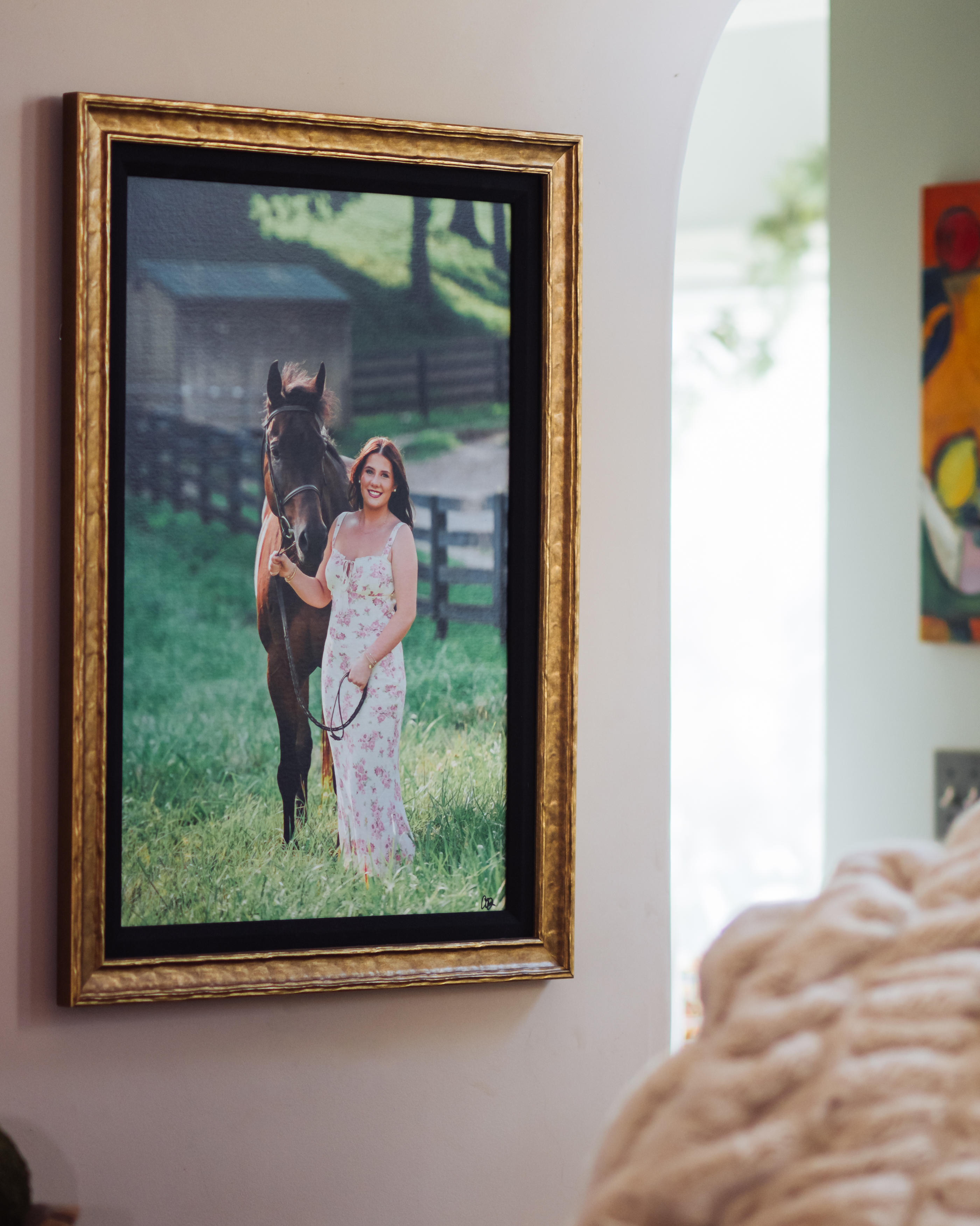 A woman stands beside her horse in a quiet green field, their shared stillness revealing trust and connection. Displayed as framed wall art in the home, the piece conveys calm confidence, pride, and a deep sense of belonging—an everyday reminder of who she is when she feels most grounded.
