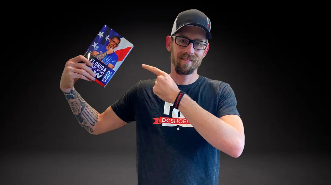 Ryan G. Thomas holding and pointing to Florida Concealed Carry Law book