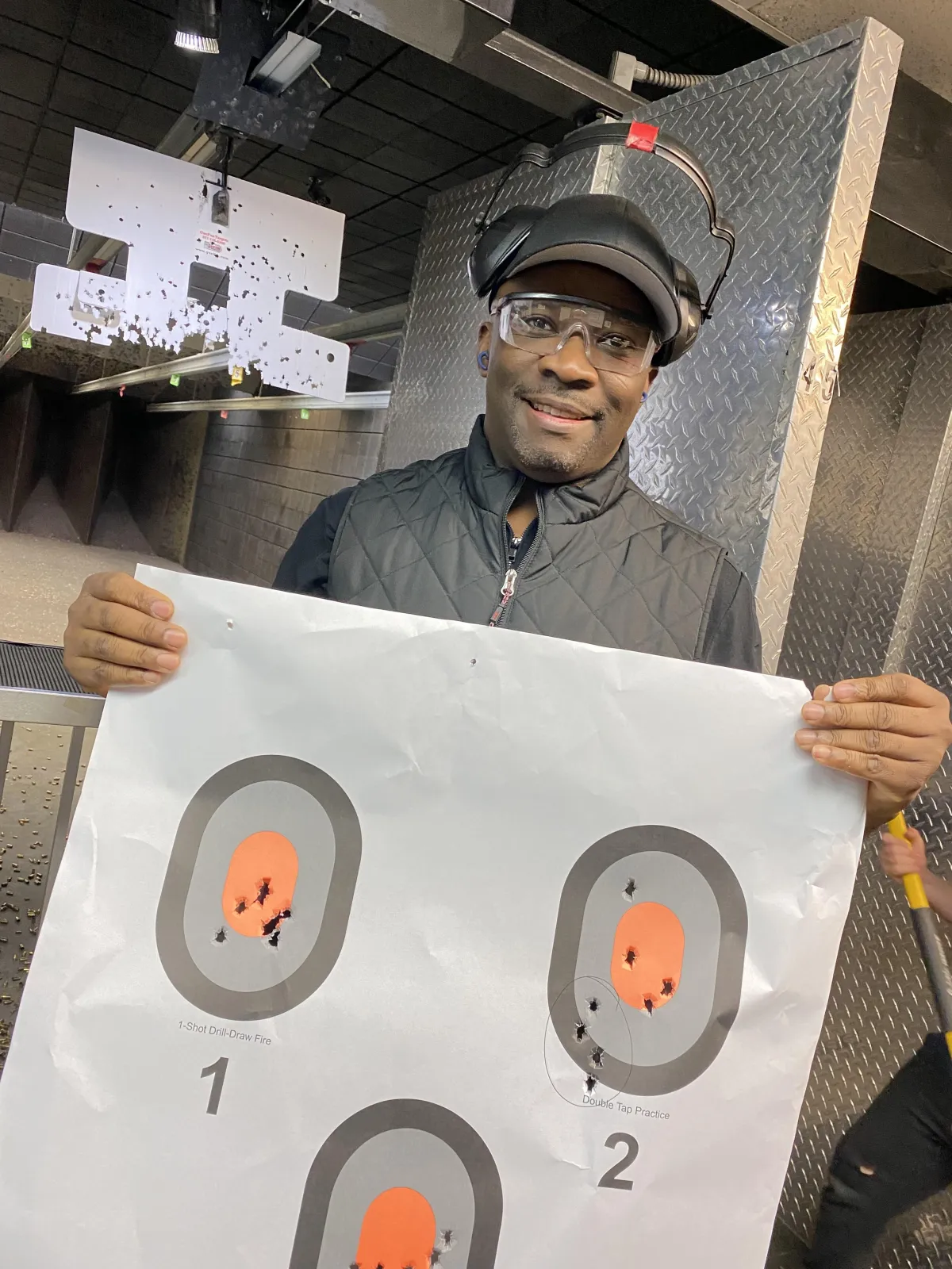 Male student holding target at gun range
