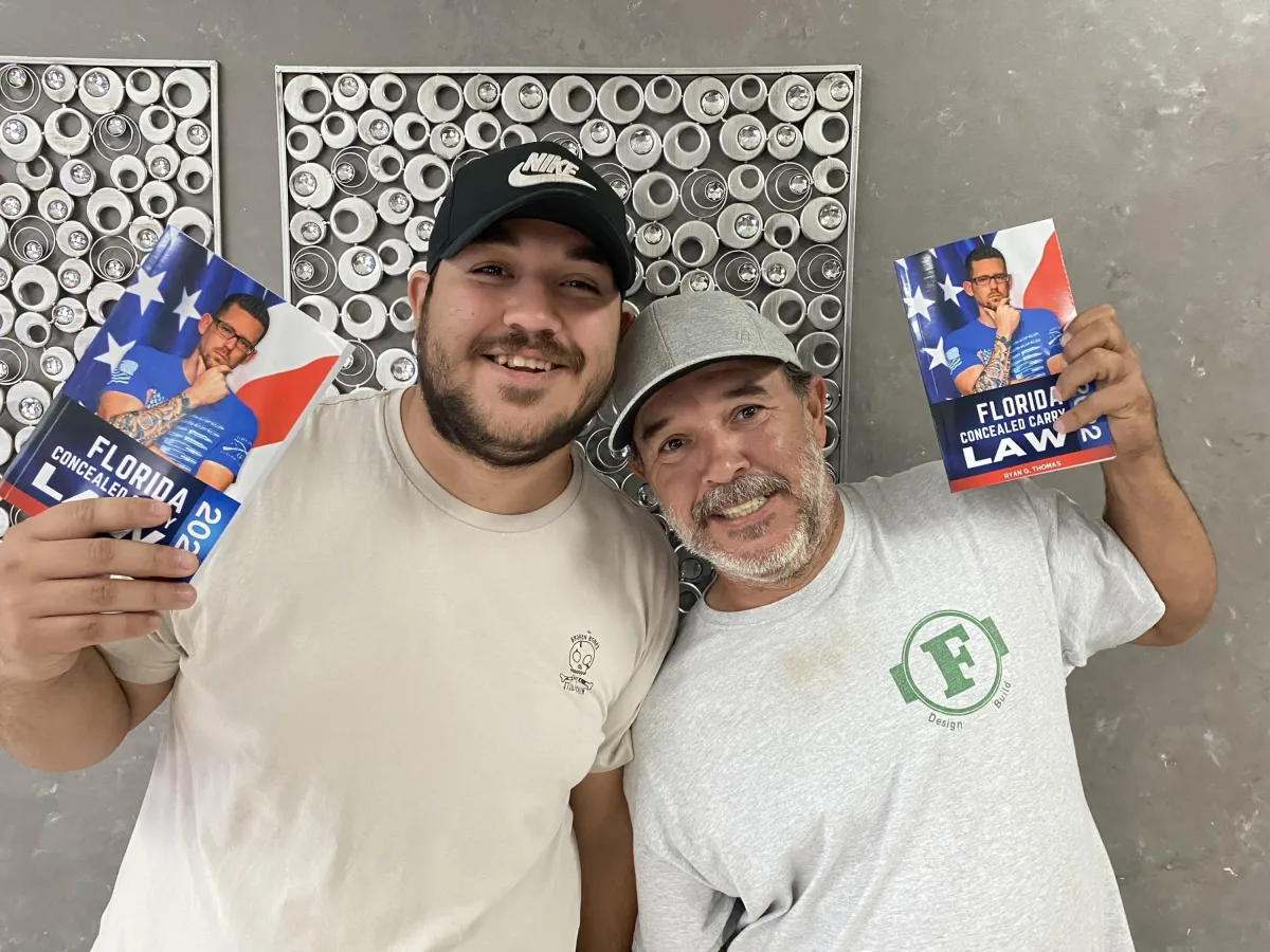 2 Men holding Florida Concealed Carry Law books