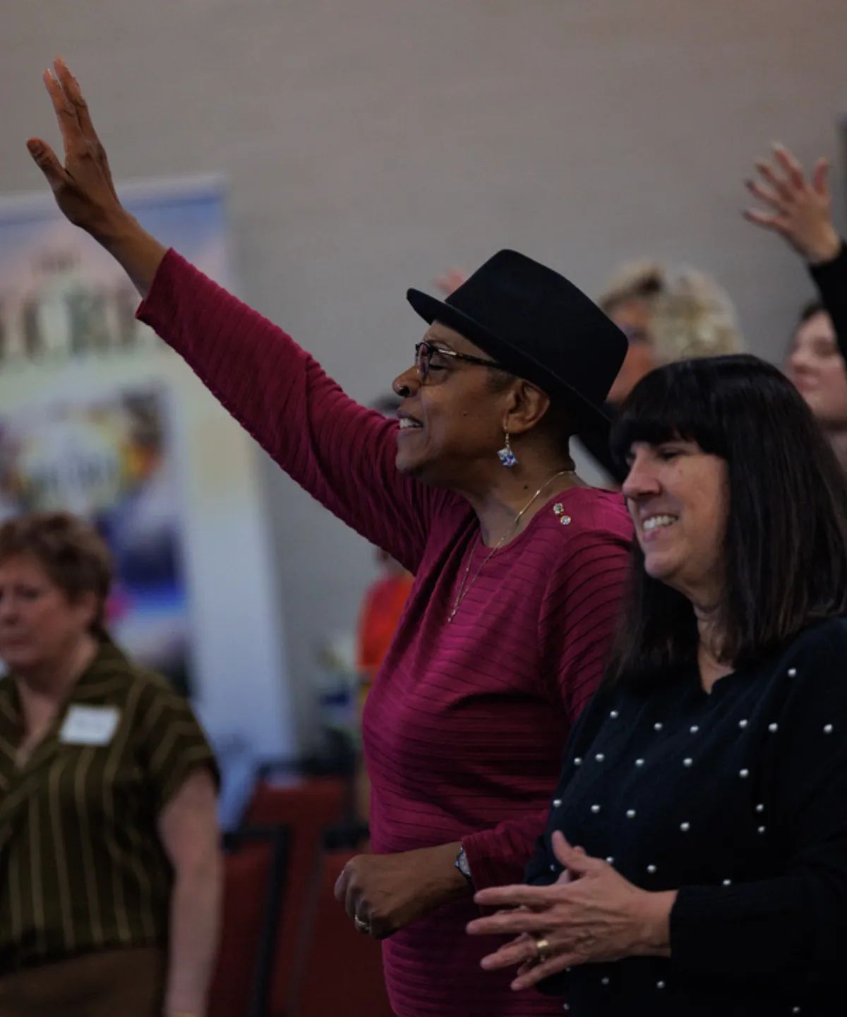 A diverse community of purpose-driven leaders gathering warmly in an inspiring conference setting