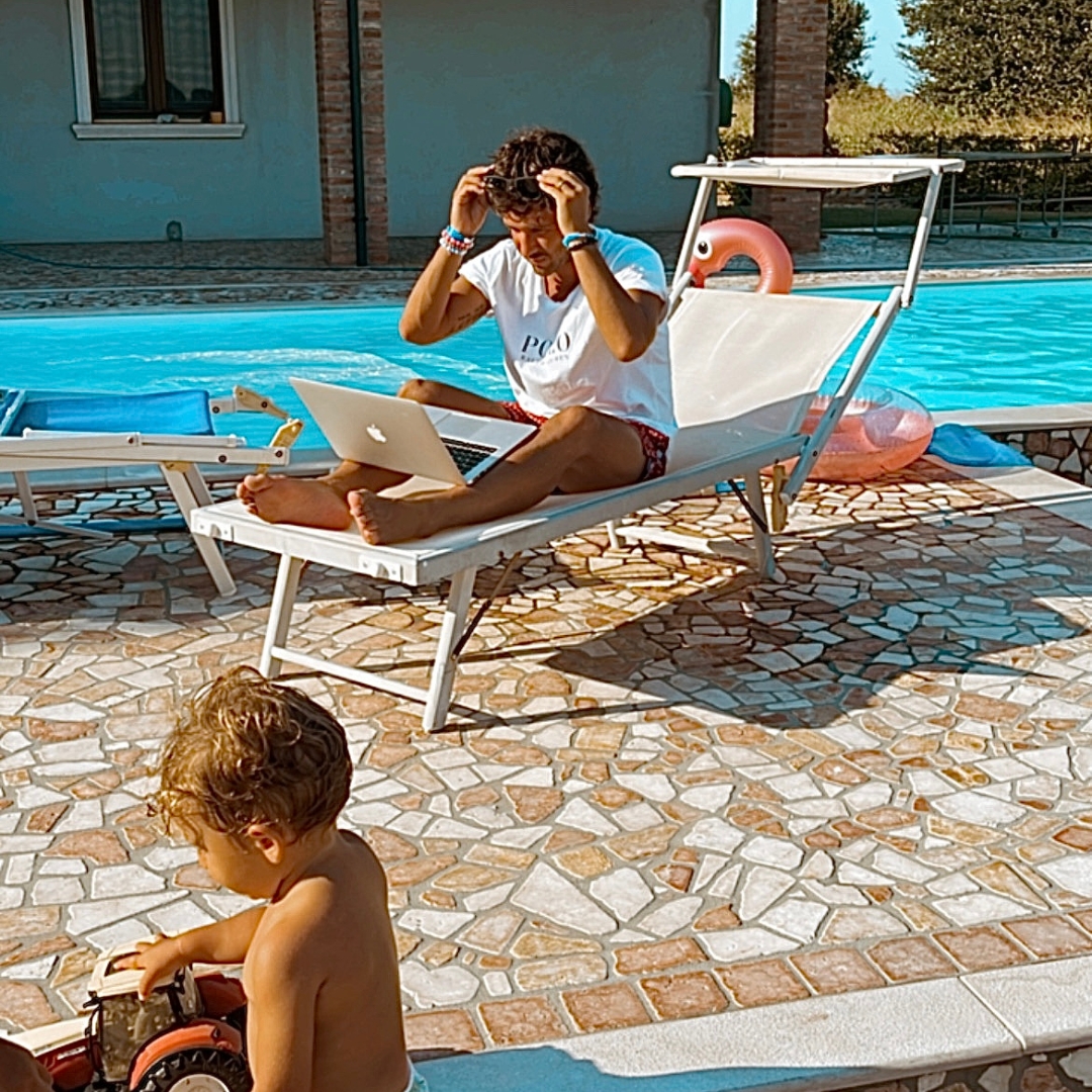 Collaborative workshop: three entrepreneurs around a glass table, city-view office, candid discussion