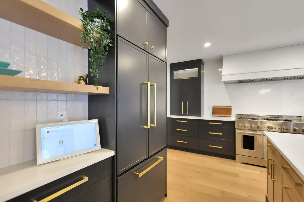 Floor-to-ceiling custom dark grey kitchen cabinets featuring soft-close drawers and gold pull handles.