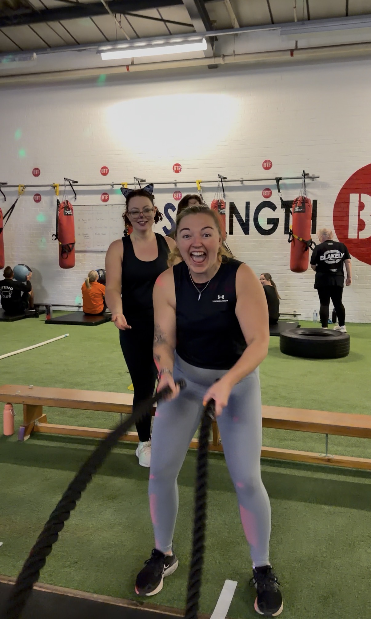 person in gray shirt holding black dumbbell