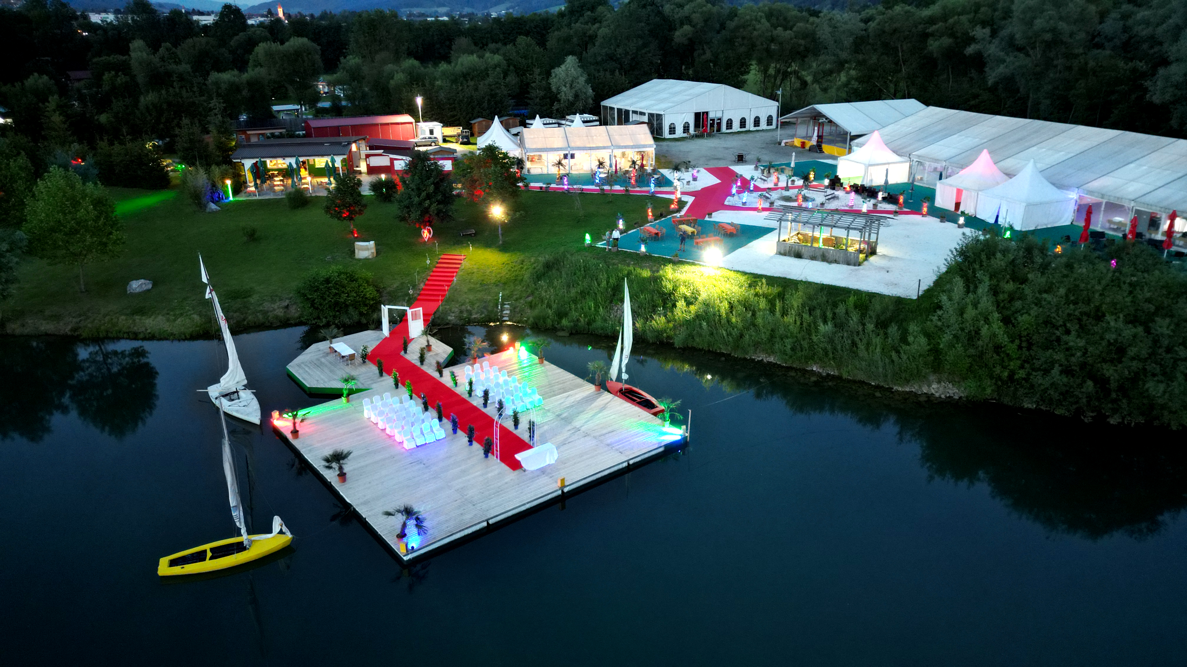 Hochzeitszeremonie am See auf einem Steg mit rotem Teppich bei Flasch City hochzeitslocation near steiermark