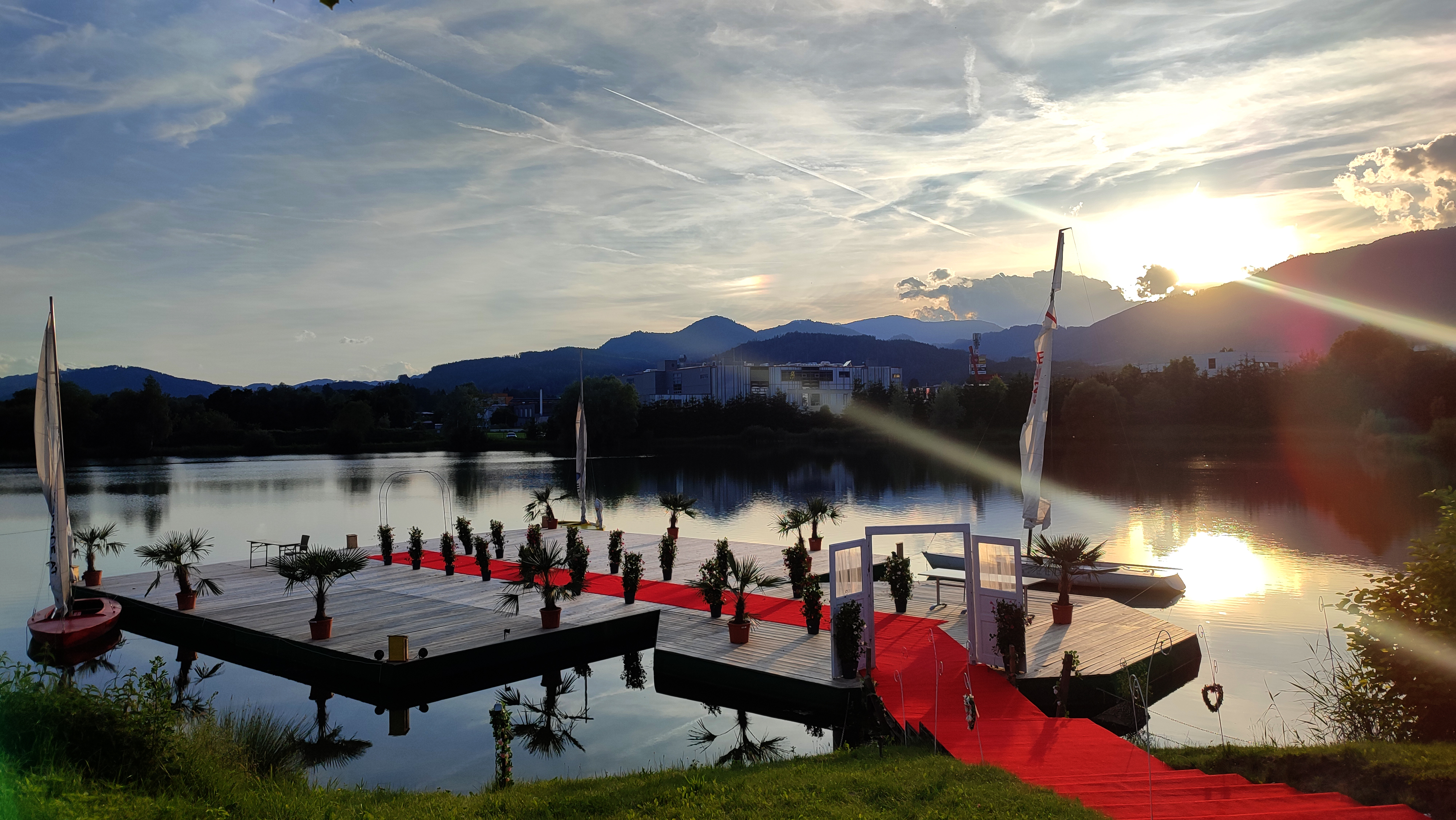 Hochzeit am See auf einem Steg mit rotem Teppich bei Sonnenuntergang bei Flasch City hochzeitslocation near steiermark