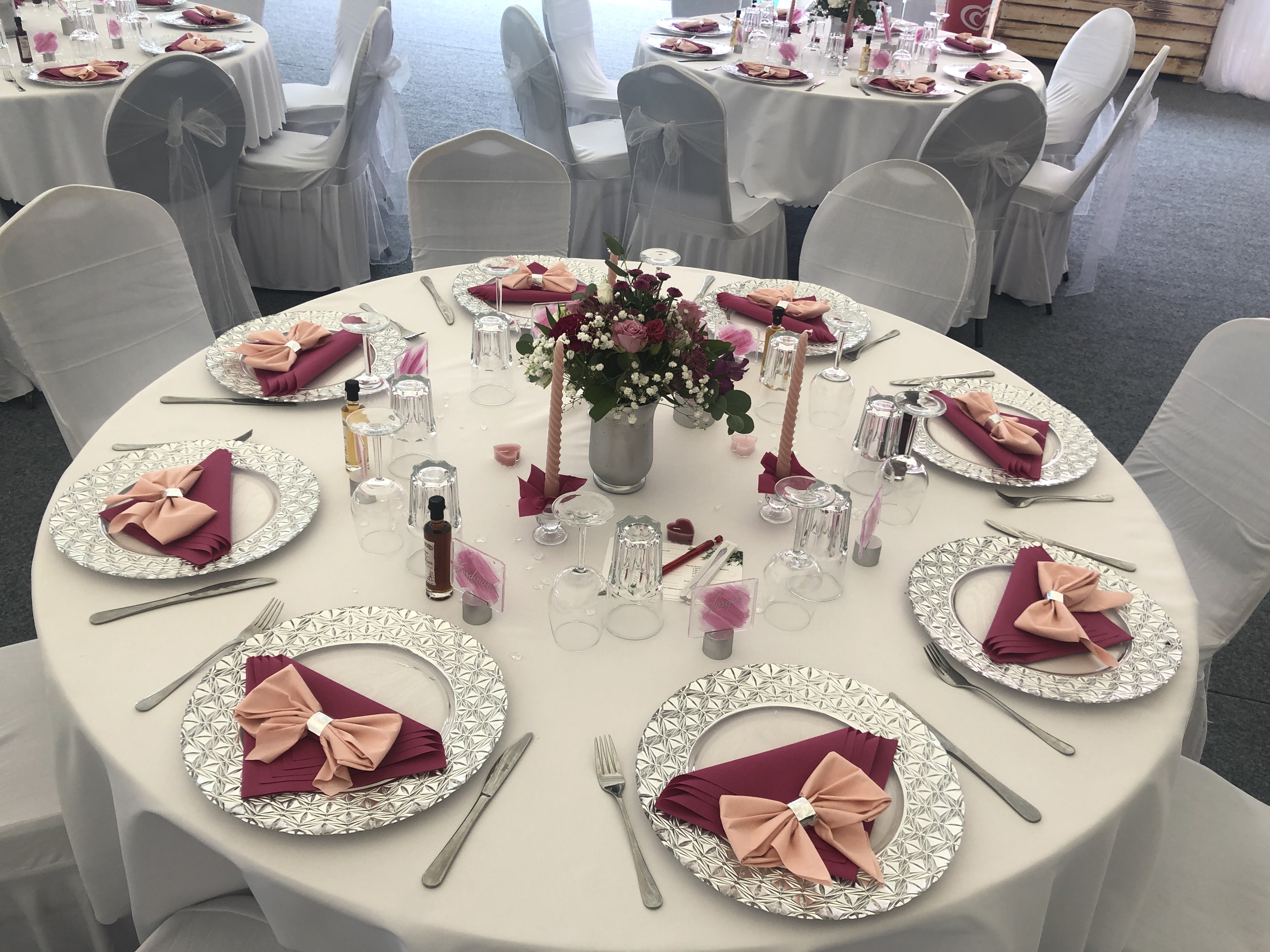 Elegante Hochzeit Tischdekoration mit rosa Servietten, silbernen Tellern und Blumenschmuck bei Flasch City hochzeitslocation near weststeiermark