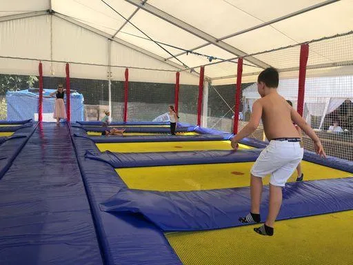 Kinder spielen auf Trampolinen im ueberdachten Spielbereich bei Flasch City Badesee, beliebte Aktivitaet fuer Familien